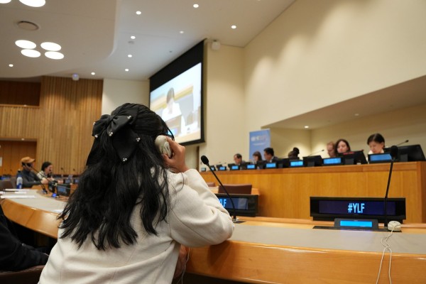 Young girl listening to a panel discussion at the 11th NPT Review Conference.